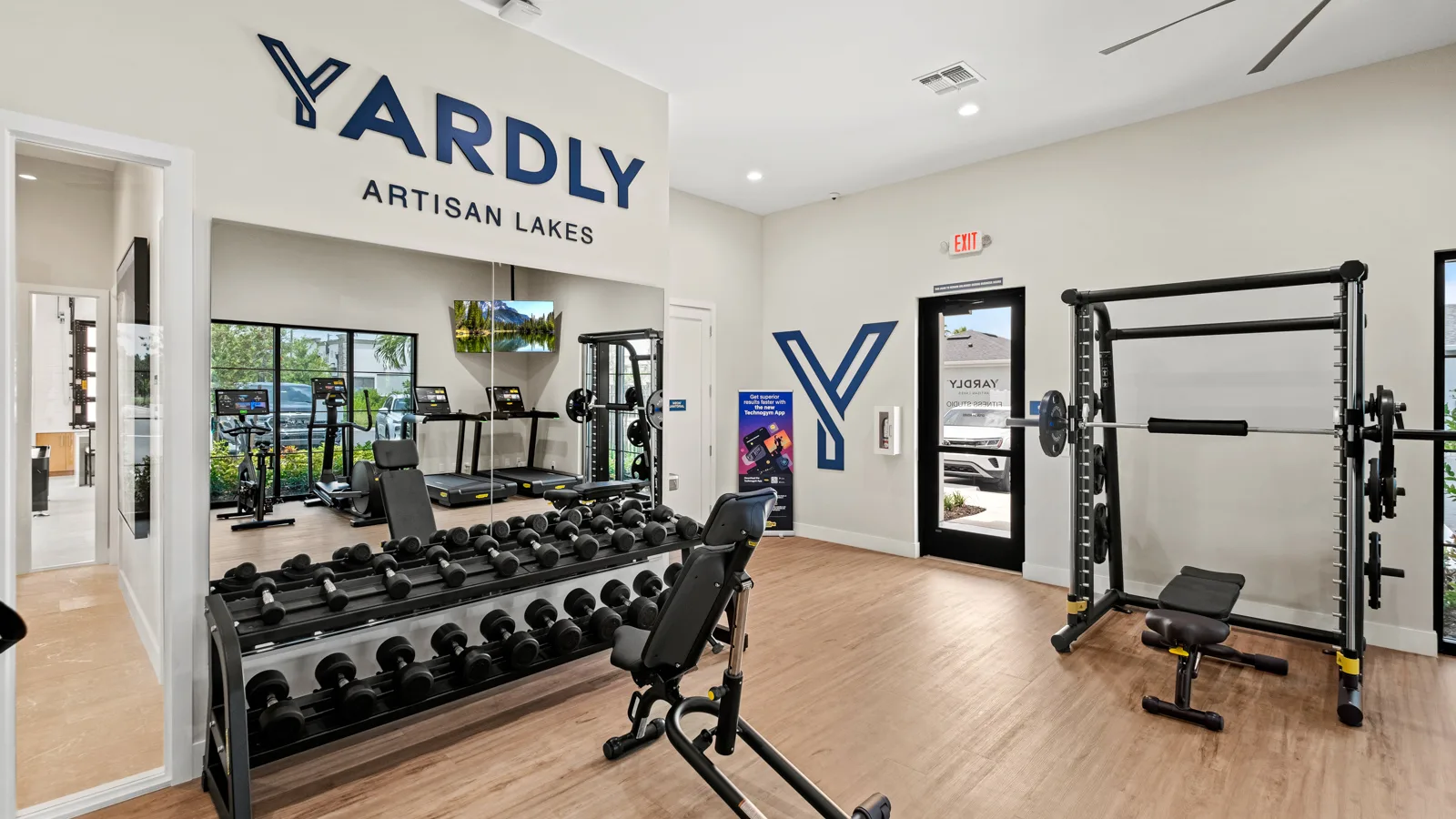 The brand-new onsite fitness center featuring Technogym equipment at Yardly Artisan Lakes in Palmetto, FL. This beautiful community, that boasts 1& 2 bedroom homes with backyards, also features a pool, clubhouse, dog park and pickle ball court.